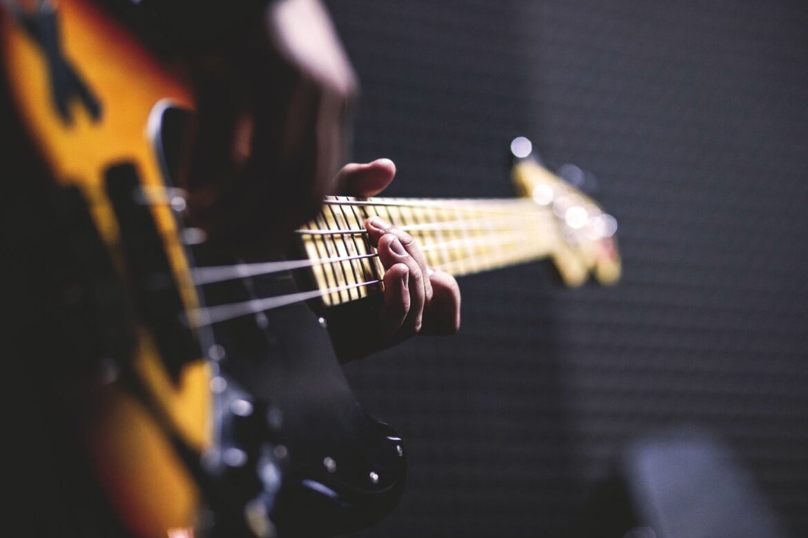 pexels-photo-96380 person playing sun burst electric bass guitar in bokeh photography