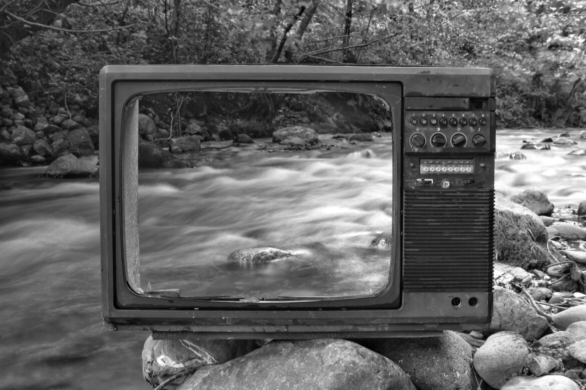 pexels-photo-3764958 retro tv on river shore near forest